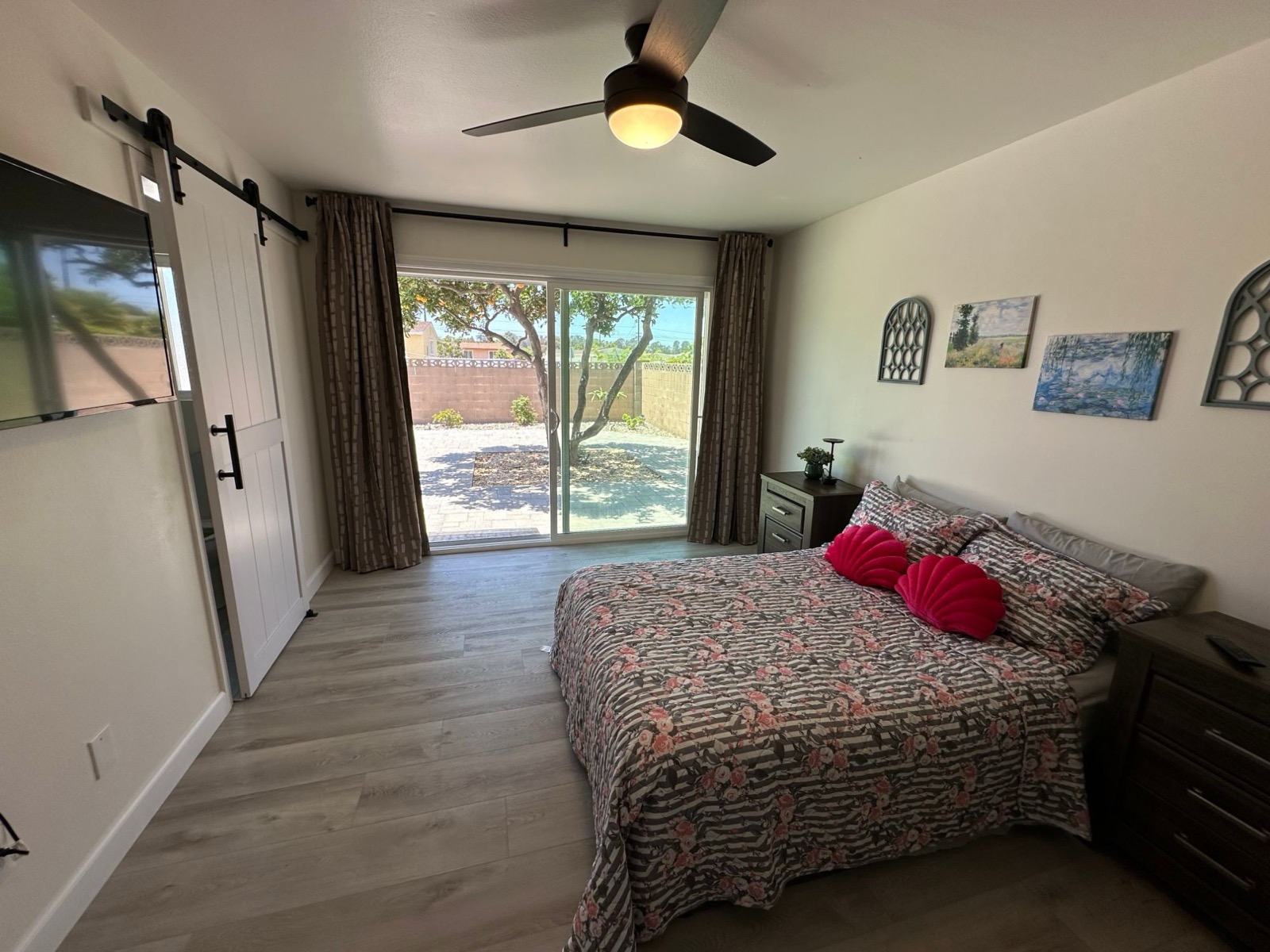 Spacious semi-private bedroom with barn door and sliding door to the backyard