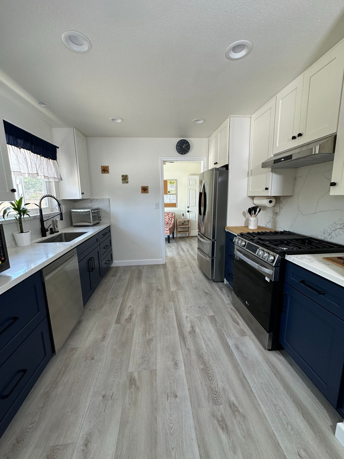 Updated kitchen with navy cabinets and stainless appliances